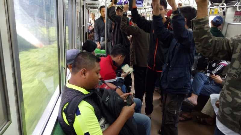 Pria Muda ini Asyik Membaca Al Quran di Commuter Line